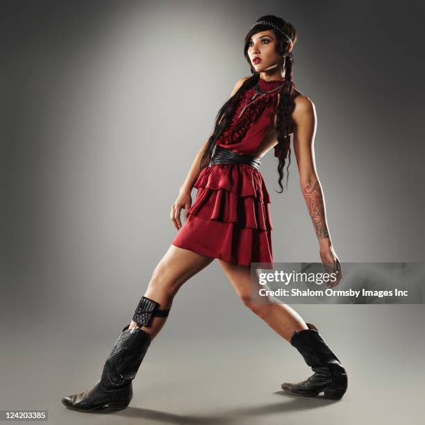 trendy mixed race woman in cowboy boots - body art stockfoto's en -beelden