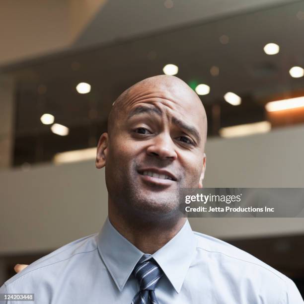 skeptical mixed race businessman - smiling mature eyes stockfoto's en -beelden