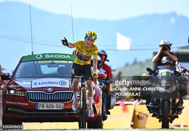Jumbo-Visma team's Danish rider Jonas Vingegaard wearing the overall leader's yellow jersey celebrates as he cycles to the finish line to win the...
