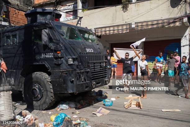 Residents of the Complexo do Alemao favela protest during a police raid in Rio de Janeiro, Brazil, on July 21, 2022. - At least four people died this...