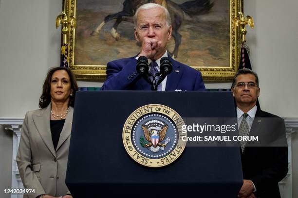 President Joe Biden coughing while accompanied by US Vice President Kamala Harris and Department of Health and Human Services Secretary Xavier...