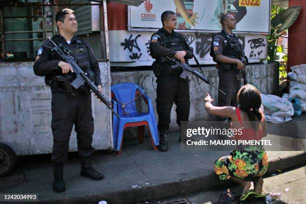 Resident of the Complexo do Alemao favela protests in front of policemen during a police raid in Rio de Janeiro, Brazil, on July 21, 2022. - At least...