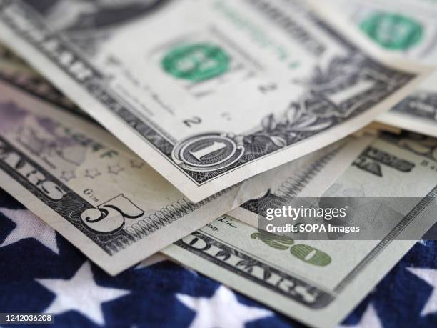 In this photo illustration, one, five and twenty dollar bills seen on display.