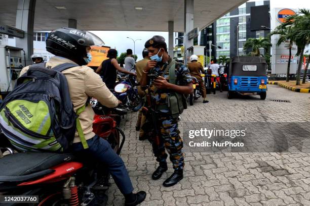 Sri Lankan military soldier is seen at a fuel station as people line up for fuel at Colombo, Sri Lanka. 21 July 2022 Inflation in Sri Lanka will peak...