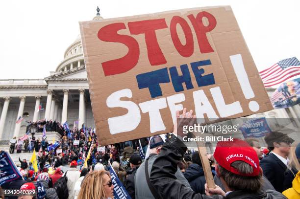 Man holds a stop the steal sign as rioters take over the steps of the Capitol on the East Front on Wednesday, Jan. 6 as the Congress works to certify...