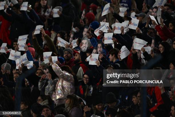 Fans of Nacional hold masks with an image of Uruguayan football star Luis Suarez and placards reading #SuárezANacional as part of a campaign to try...