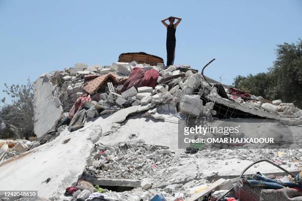 Syrian youth gestures above debris following a Russian air strike on the outskirts of the rebel-held city of Jisr al-Shughur in Syria's northwestern...