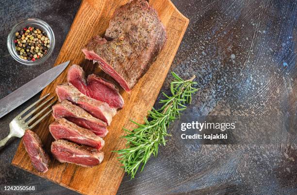 steak de bœuf tranché grillé sur la planche à découper - mode de cuisson des aliments photos et images de collection