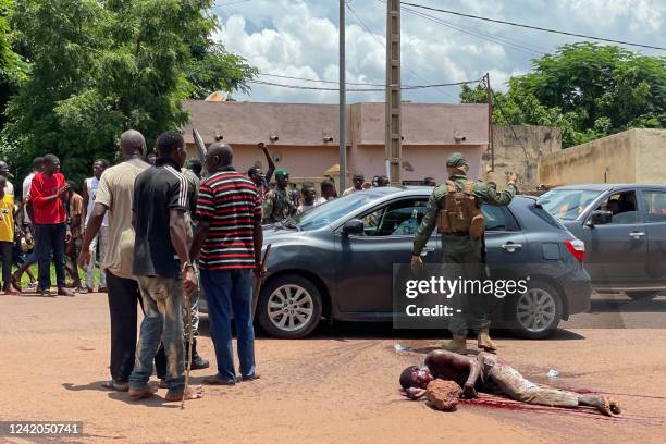 Graphic content / A man suspected of taking part in thwarted "terrorist" attack lies motionless on the floor after being beaten by a crowd, in front...