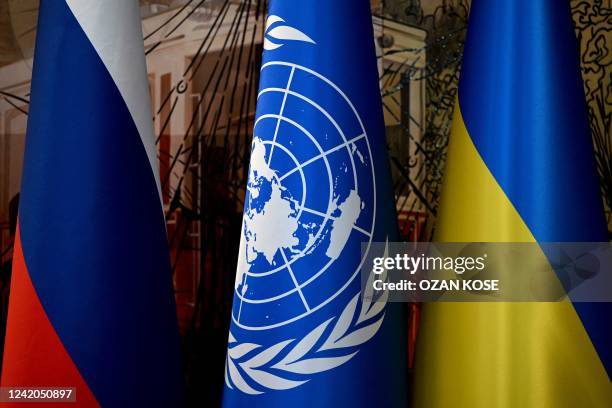 This photograph taken on July 22 shows a Russian national flag, a United Nations flag and a Ukrainian national flag in Istanbul before the signature...