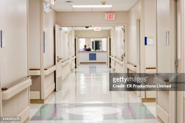 nurse working at hospital nurses station - corridor foto e immagini stock