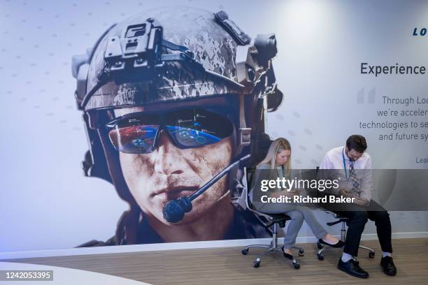 Lockheed-Martin employees look at their phones at US Defence contractor's exhibition stand during the Farnborough Airshow, on 22nd July 2022, at...