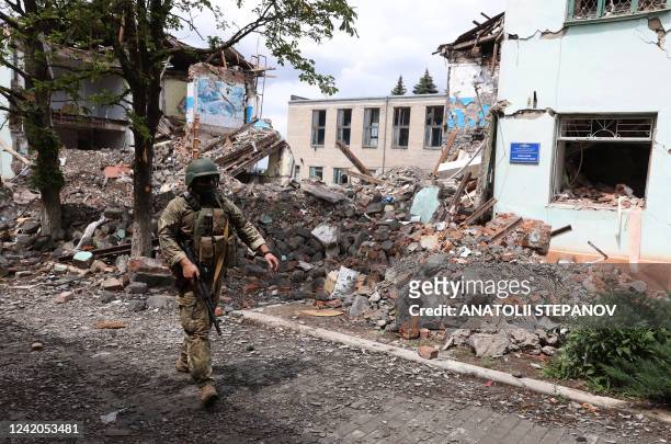 Ukrainian serviceman passes by destroyed buildings in the Ukrainian town of Siversk, Donetsk region on July 22, 2022 amid the Russian invasion of...