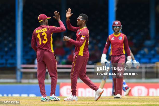 Akeal Hosein and Sharmarh Brooks of West Indies celebrate the dismissal of Suryakumar Yadav of India during the 1st ODI match between West Indies and...