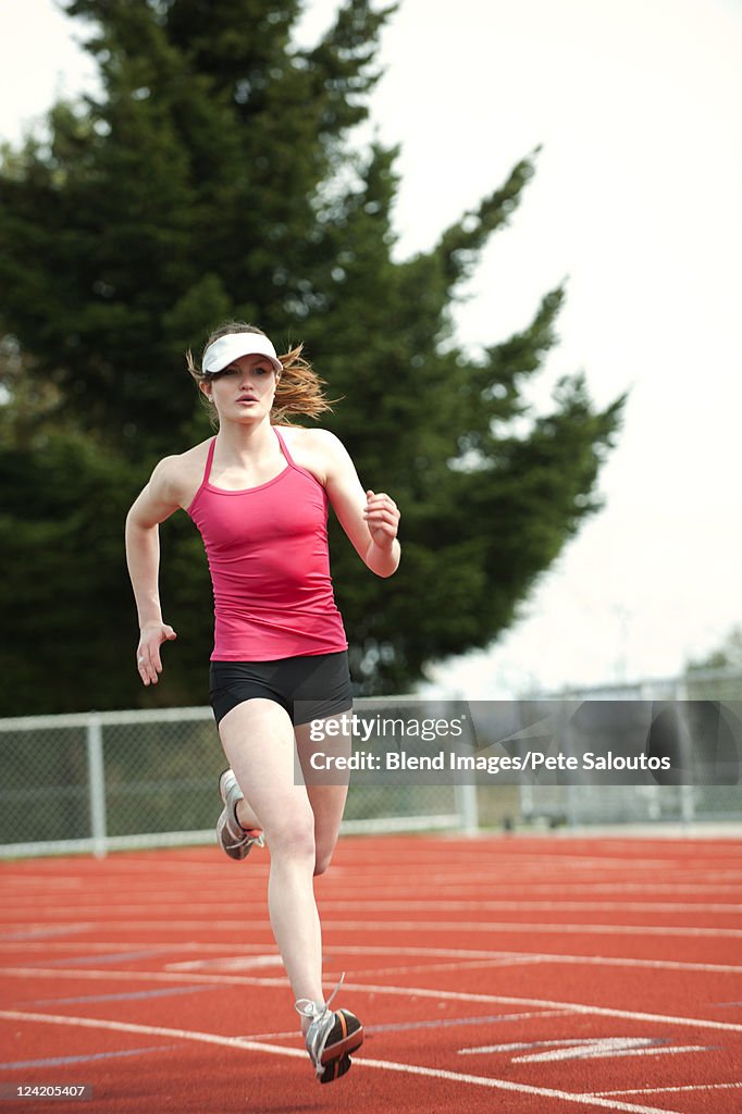 Mixed race teenager running on track