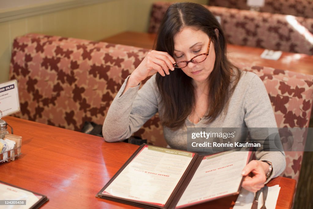 Caucasian woman looking at menu in restaurant