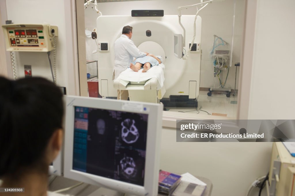 Doctor talking to patient on MRI scanner in hospital