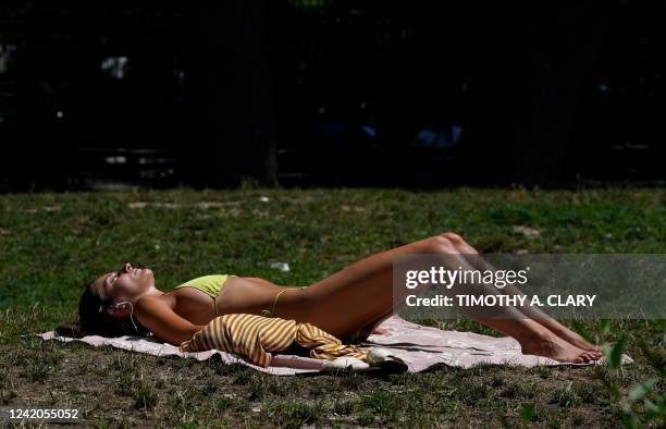 Woman sunbathes in Washington Square Park on July 22 in New York. - Much of the United States is expected to experience a dangerous record setting...