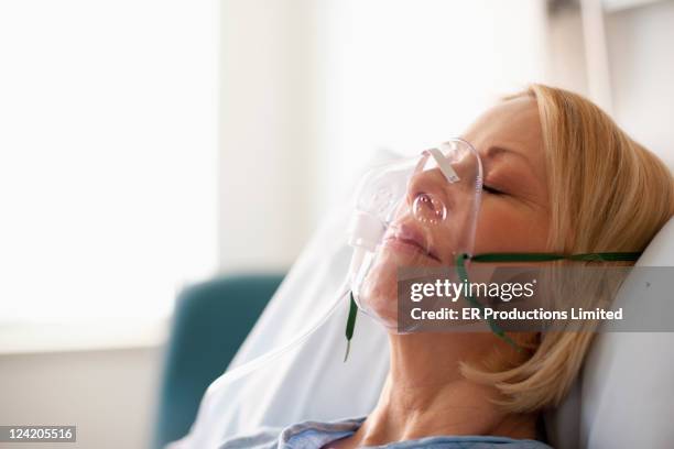 caucasian patient laying in hospital bed in oxygen mask - maschera per l'ossigeno foto e immagini stock