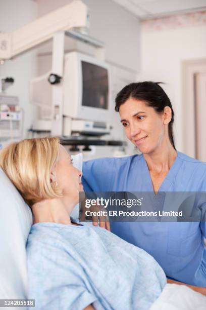 nurse comforting patient in hospital bed - contact avec les patients photos et images de collection