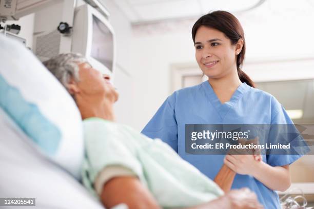 nurse comforting patient in hospital bed - patient in bed stockfoto's en -beelden