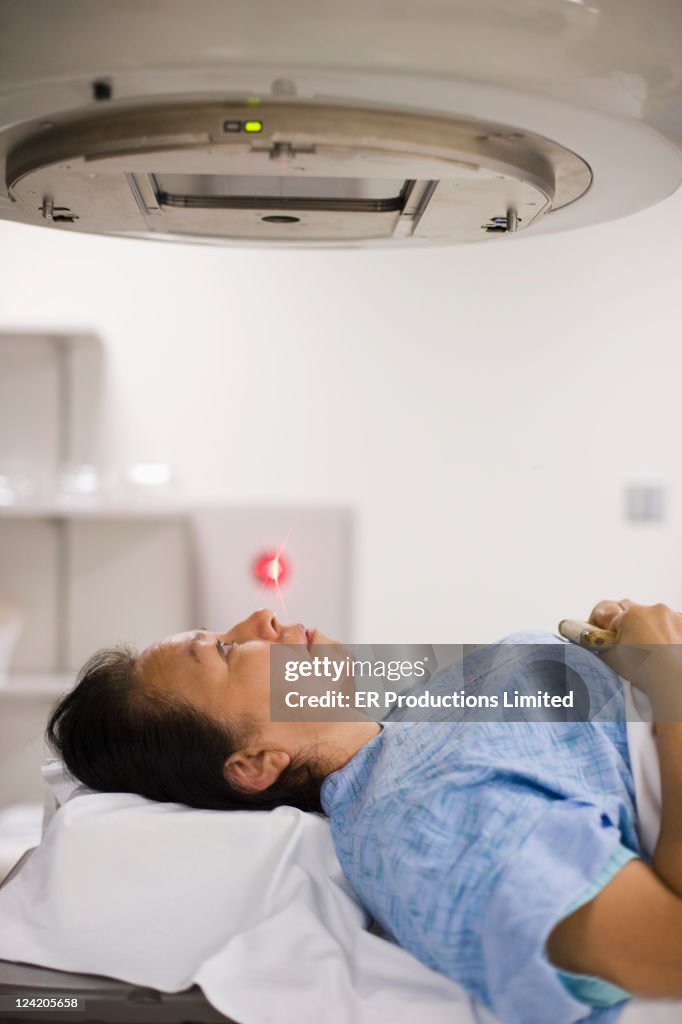 Asian woman laying on x-ray table