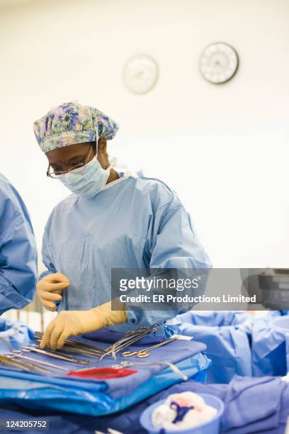 nurse organizing operating equipment in operating room - doctor reaching stock pictures, royalty-free photos & images