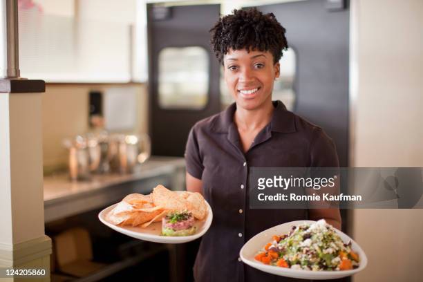 african american waitress carrying food on plates - diner plates stock pictures, royalty-free photos & images
