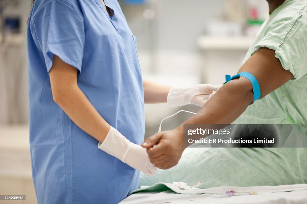 Nurse taking blood from patient in hospital