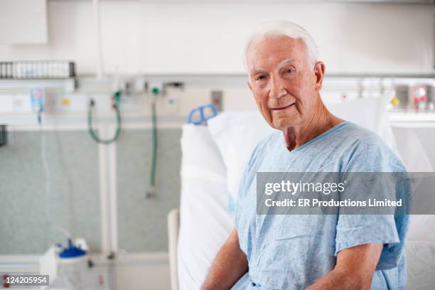 em roupa de hospital sentado na cama - hospital gown imagens e fotografias de stock