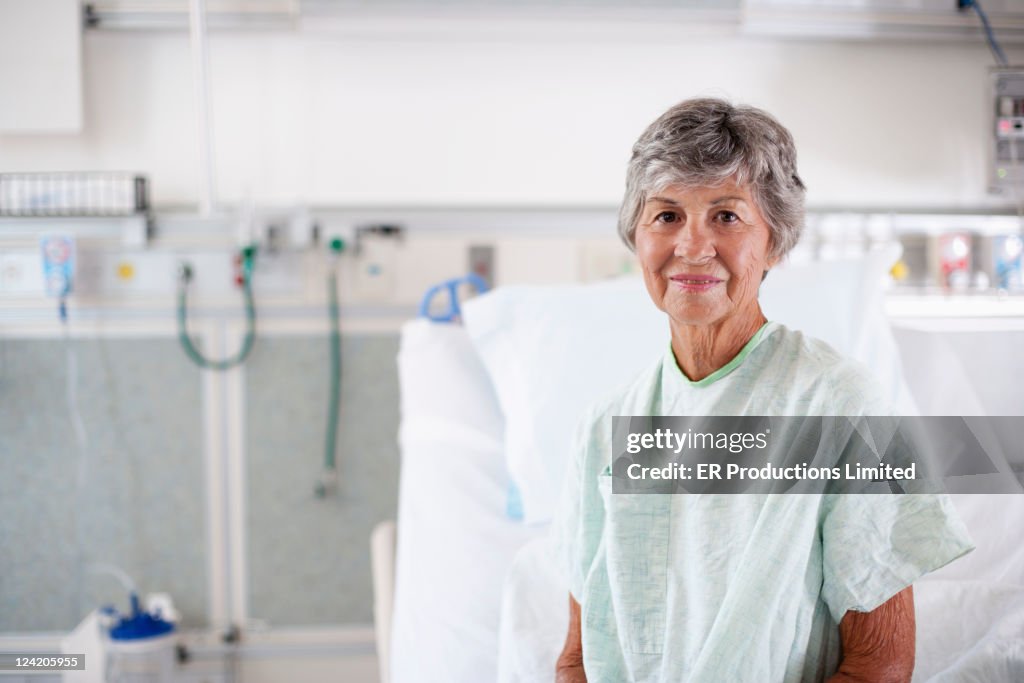 Caucasian patient in hospital gown sitting in hospital bed
