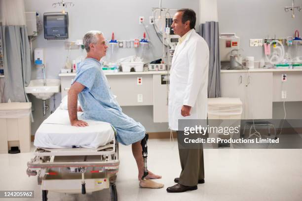 doctor talking to patient with artificial leg - doctor side view stock pictures, royalty-free photos & images