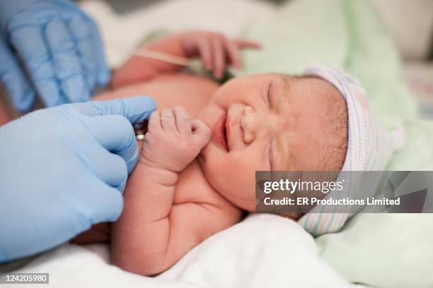 doctor listening to newborn baby's heartbeat - examining newborn stock pictures, royalty-free photos & images