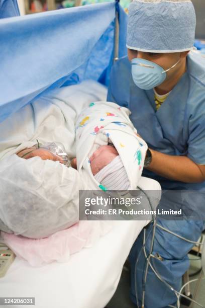 father showing newborn baby girl to mother in operating room - diversity showcase arrivals stock pictures, royalty-free photos & images