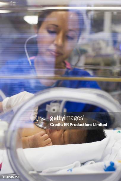 看護師を聞くの赤ちゃん男の子の「ハートビート」でふ卵器 - 新生児集中治療室 ストックフォトと画像