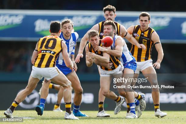 Dylan Moore of the Hawks is tackled by Luke McDonald of the Kangaroos during the 2022 AFL Round 19 match between the North Melbourne Kangaroos and...