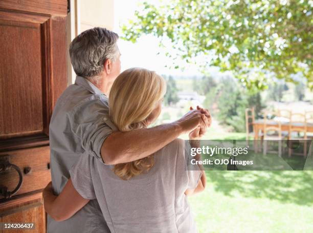 rear view of a couple holding hands and standing at door - couple back stock pictures, royalty-free photos & images