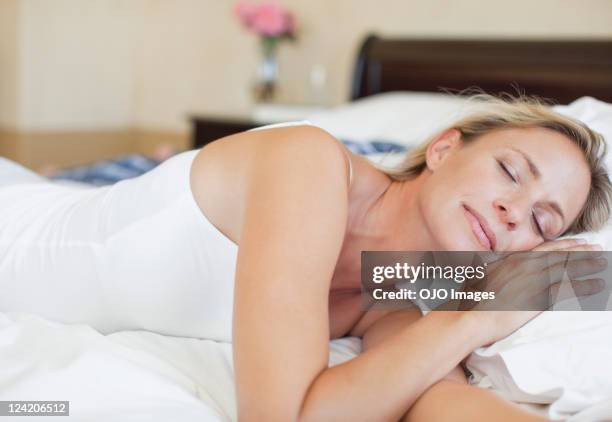 mature woman in bed sleeping peacefully - lying on side stock pictures, royalty-free photos & images