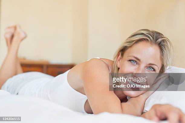 beautiful mature woman lying in bed - beautiful blondes stockfoto's en -beelden