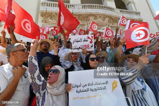 Tunisian protesters raise flags and placards on July 23 during a demonstration along Habib Bourguiba avenue in the capital Tunis, against their...