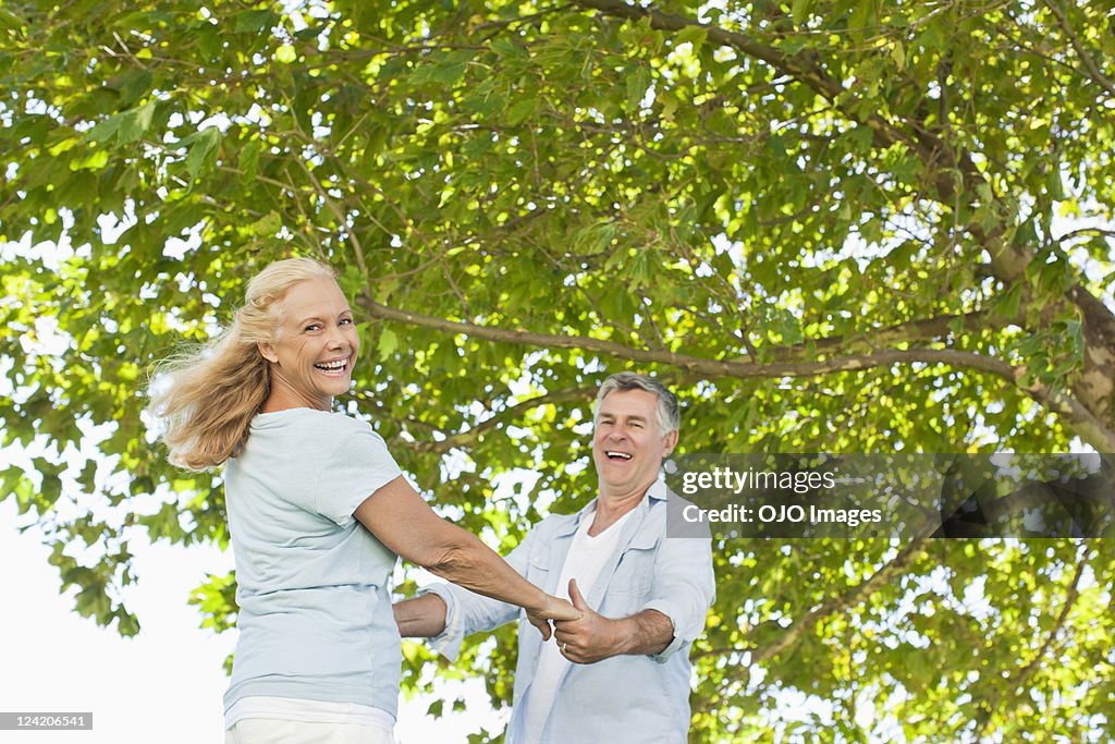 朗らかマチュア遊び心のある夫を持つ女性の手の芝生