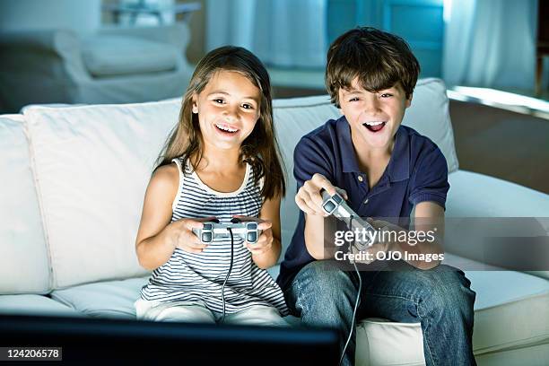 children playing video game at home - brother sister stock pictures, royalty-free photos & images