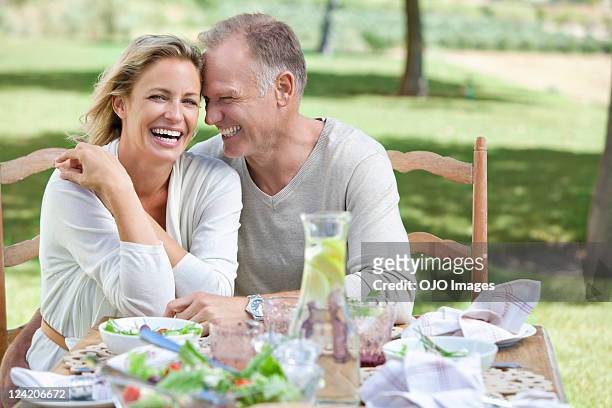portrait of cheerful mature couple enjoying breakfast in lawn - healthy older couple stockfoto's en -beelden