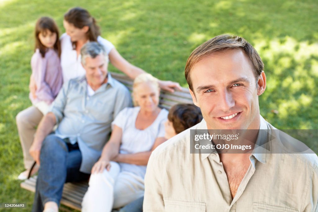 Portrait of father with his family in the background in park