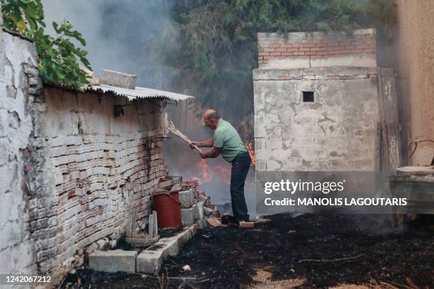 Local resident tries to save his property at Vatera coastal resort on the eastern island of Lesbos on July 23, 2022. Residents were evacuated as the...