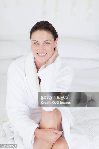 portrait of a beautiful mid adult woman smiling in bathrobe - woman in bathrobe stock pictures, royalty-free photos & images