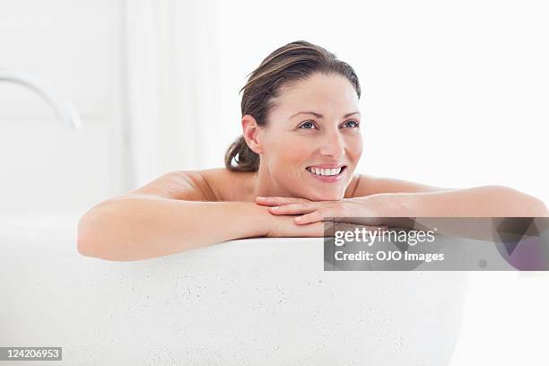 close-up of beautiful mid adult woman smiling in bathtub - bad thoughts stockfoto's en -beelden