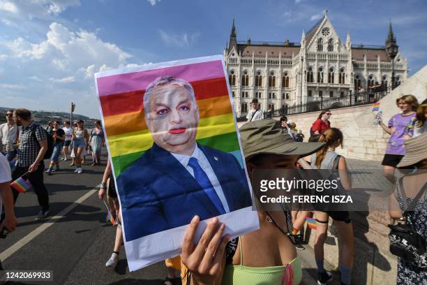 Participant holds up a made-up portrait of Hungary's President Viktor Orban during the LGBTIQA+ Pride Parade in Budapest on July 23 in memory of the...