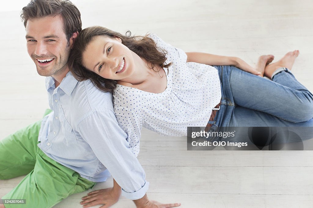 Cheerful mid adult couple smiling and leaning on each other