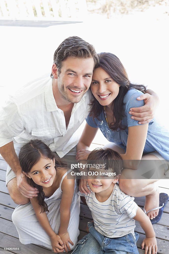 Family portrait of happy couple smiling with cute kids